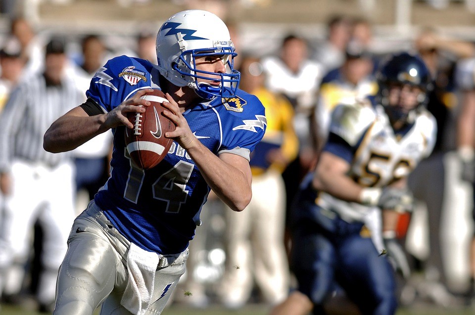 American Football player in action. Blue jersey and white helmet witl lightning on